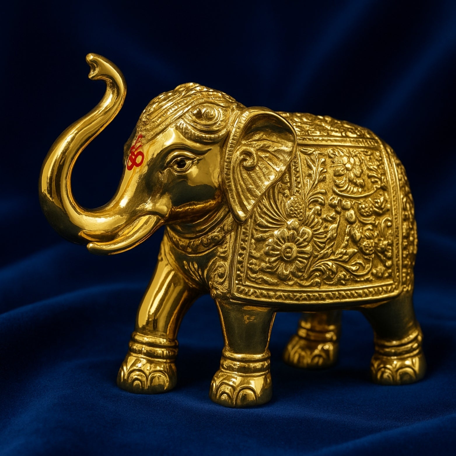 Decorative gold elephant figurine on a blue fabric background