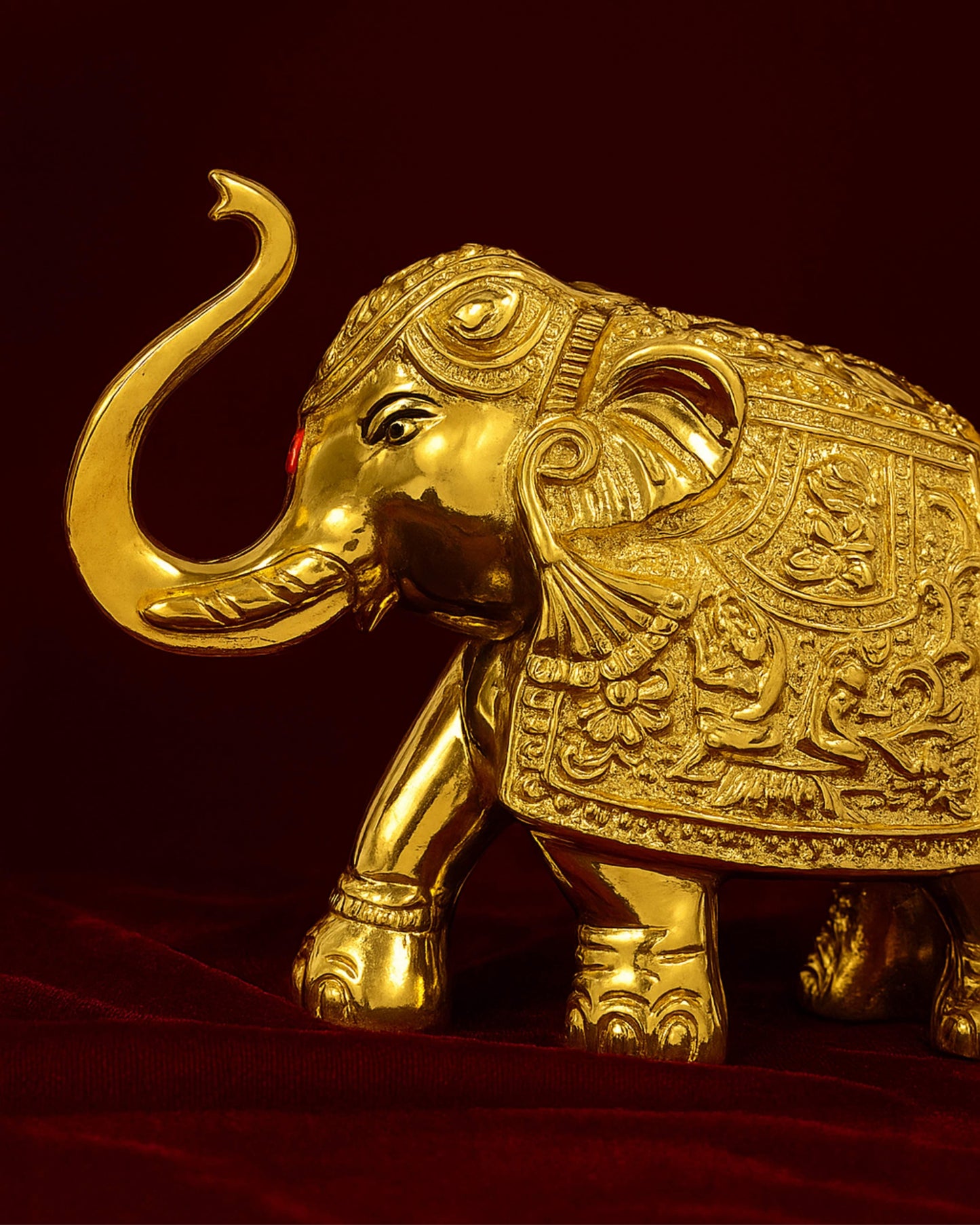 Decorative gold elephant figure on a red background
