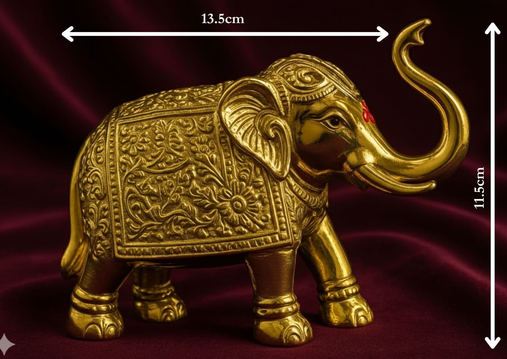 Decorative gold elephant figurine with intricate patterns on a dark red background
