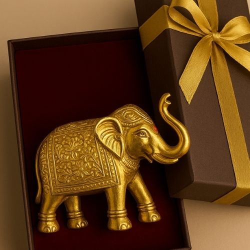 Gold elephant figurine in an open gift box with a gold ribbon.