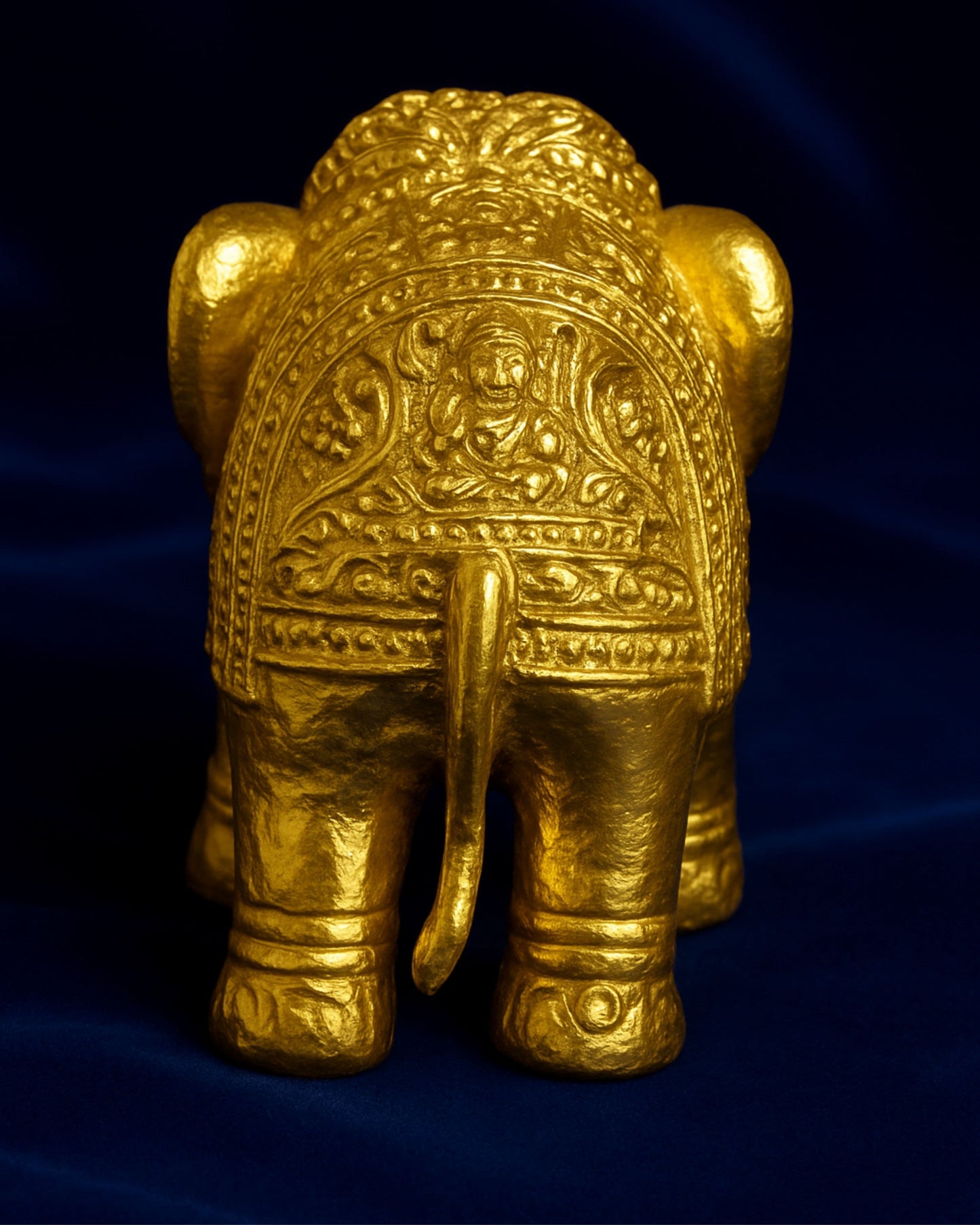 Decorative gold elephant figure on a dark blue background