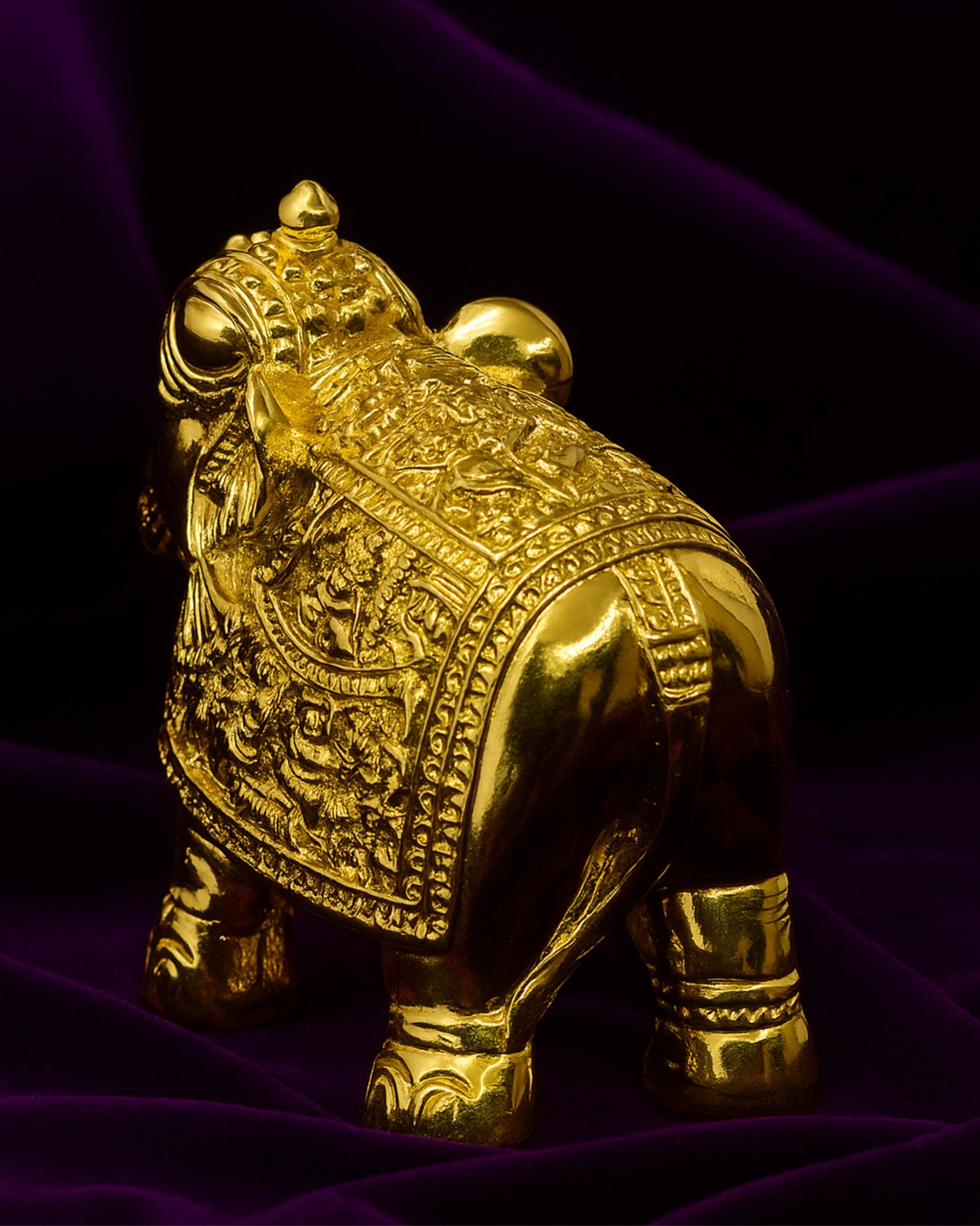 Gold bull figurine on a purple fabric background